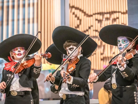 kids in mariachi outfits with painted faces playing violins