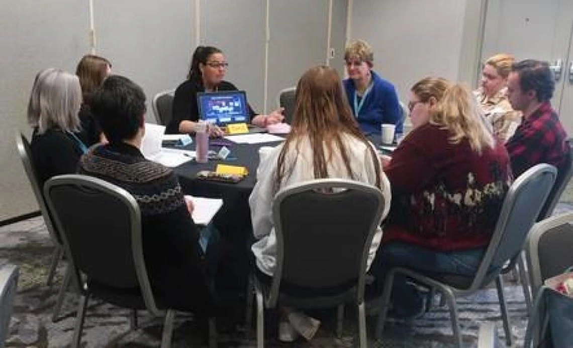 a group of adults sitting around a table talking