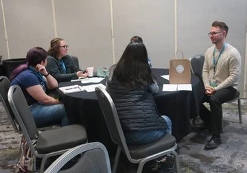 group of adults sitting around a table in a conference room